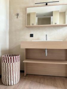 La salle de bains est pourvue d'un lavabo et d'un miroir. dans l'établissement Hôtel De La Marine, à Arromanches-les-Bains