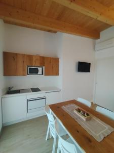 uma cozinha com uma mesa de madeira e uma bancada em Fienilemare casa vacanze em Roseto degli Abruzzi