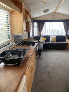 uma cozinha e sala de estar com um sofá numa caravana em Static van on Smallgrove in Ingoldmells em Skegness