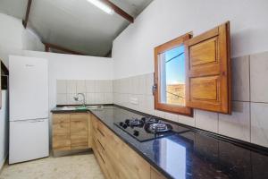 a kitchen with a counter top and a window at Cuevas Lomo La Palma in San Bartolomé