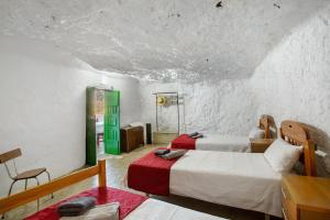 a room with two beds and a green door at Cuevas Lomo La Palma in San Bartolomé