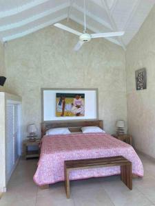 a bedroom with a bed with a pink bedspread at Villa Águila in Las Terrenas