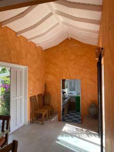 Habitación con pared de color naranja y techo blanco. en Villa Águila, en Las Terrenas