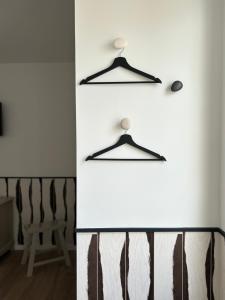 a room with a white wall with two hangers at Hôtel De La Marine in Arromanches-les-Bains