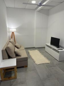 a living room with a couch and a desk with a laptop at Apart Hotel Concepcion in Concepción