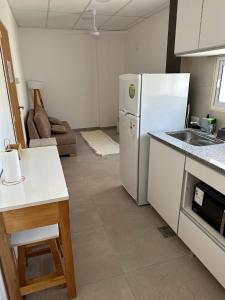 a kitchen with a white refrigerator and a sink at Apart Hotel Concepcion in Concepción