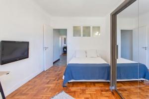 una camera con letto e TV a schermo piatto di Cassin - Bel appartement T3 proche de la mer a Nizza