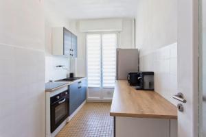 a kitchen with a sink and a refrigerator at Cassin - Bel appartement T3 proche de la mer in Nice