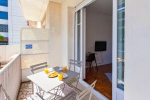 a balcony with a table with orange juice on it at Bel appartement T3 proche de la mer in Nice