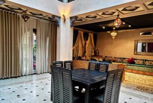 comedor con mesa negra y sillas en Villa Ghali de Luxe & Golf, en Marrakech