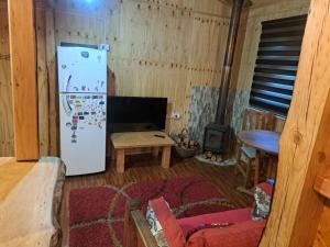 a living room with a refrigerator and a table at Casa, central a orilla de playa in Puerto Williams