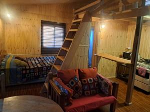 a room with a bunk bed and a staircase in a cabin at Casa, central a orilla de playa in Puerto Williams