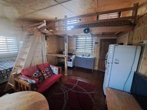 a living room with a loft bed and a refrigerator at Casa, central a orilla de playa in Puerto Williams