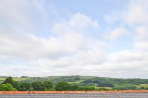 uma vista para as colinas a partir do telhado de uma casa em The Hayloft em Newchurch