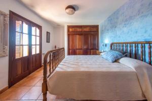 a bedroom with a large bed with a wooden frame at 4 bedrooms villa with private pool terrace and wifi at Sant Josep de sa Talaia 2 km away from the beach in Sant Jordi