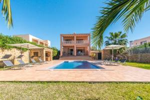 a villa with a swimming pool and a house at 4 bedrooms villa with private pool terrace and wifi at Sant Josep de sa Talaia 2 km away from the beach in Sant Jordi