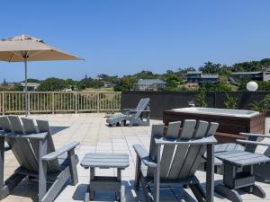 a patio with chairs and a table and an umbrella at 15 Praslin in Ramsgate