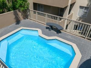 a small swimming pool on a patio with a balcony at 15 Praslin in Ramsgate