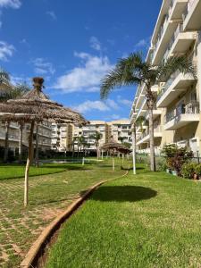un edificio con un patio de césped con palmeras en Bouznika Beach appartement de luxe avec piscine, en Bouznika