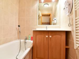 a bathroom with a tub and a sink and a mirror at Appartement Valloire, 3 pièces, 5 personnes - FR-1-263-224 in Valloire