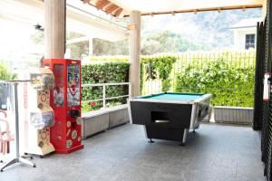 a patio with a pool table and two machines at Camping Residence & Lodge Orchidea in Baveno