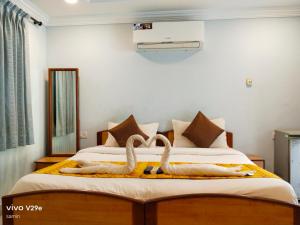 a bedroom with two swans towels on a bed at Calangute Beach Empire in Calangute
