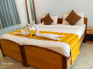 two swans sitting on two beds in a room at Calangute Beach Empire in Calangute