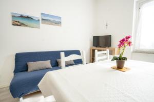 een slaapkamer met een bed en een blauwe bank bij Appartamento Libeccio a 300m dalla spiaggia in Golfo Aranci