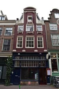 un alto edificio di mattoni rossi su una strada cittadina di Rembrandtplein house A ad Amsterdam