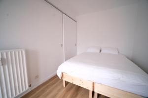a white bedroom with a bed and a radiator at Smart Appart - City Center Liege in Liège