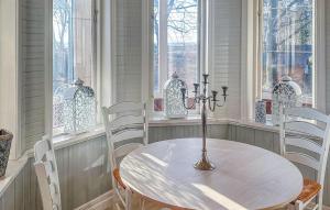 a table and chairs in a room with windows at Villa Sommarro in Ystad