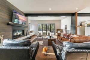 a living room with leather furniture and a fireplace at Luxurious 4BR 3 Min to Palisades Tahoe in Olympic Valley