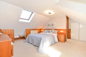 a attic bedroom with a bed and a window at The Wing at Fox Hollow in Ventnor