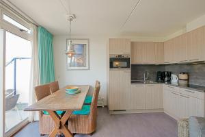 a kitchen with a table and a dining room at Appartement Seinpost 26 - Callantsoog in Callantsoog
