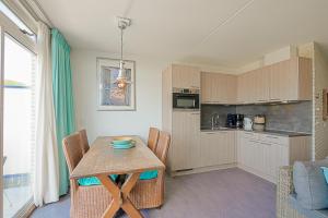 a kitchen with a table and chairs in a room at Appartement Seinpost 26 - Callantsoog in Callantsoog