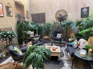 a living room filled with furniture and lots of plants at Petit Trianon - Appartement de Luxe in Aix-en-Provence