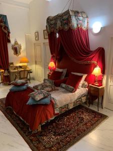 a bedroom with a canopy bed with red curtains at Petit Trianon - Appartement de Luxe in Aix-en-Provence
