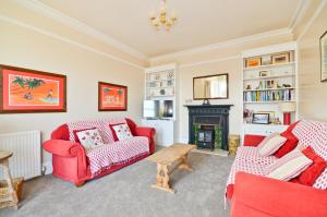 a living room with two red chairs and a fireplace at Red House in Seaview
