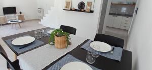 a dining room with a table with white plates and chairs at LA MARCELINO in Patagones
