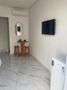 Pousada Bella Flor في بايا فورموزا: غرفة معيشة مع تلفزيون وغرفتين جلوس