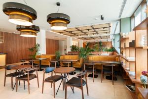 a restaurant with wooden tables and chairs and benches at Leonardo Hotel San Sebastián in Donostia-San Sebastián