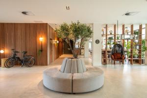 a lobby with a table with a tree in it at Leonardo Hotel San Sebastián in Donostia-San Sebastián