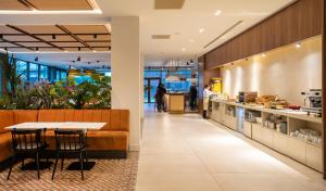 a restaurant with a table and chairs and a counter at Leonardo Hotel San Sebastián in Donostia-San Sebastián