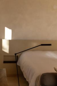 a bedroom with a white bed with a lamp next to it at Cabañas Agotzenea in Zubiri