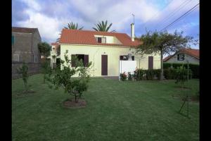 a white house with a red roof and a yard at Vila Nova in Vila Franca do Campo