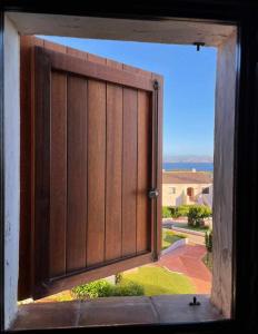 a window with a wooden door with a view at PortoCervo Cala Del Faro in Arzachena