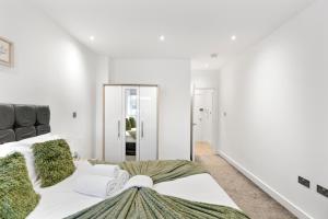 a white bedroom with a large bed and a mirror at Bright and spacious Apartment - Excellent Location in London