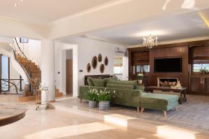 a living room with a green couch and a fireplace at Vento Imperiale Estate in Rhodes Town