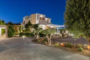 a large white house with trees in front of it at Vento Imperiale Estate in Rhodes Town