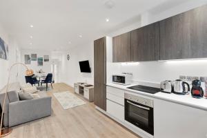 a kitchen and living room with a couch and a table at Bright and spacious Apartment - Excellent Location in London